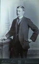 Vintage black and white photo of a young Victorian man with moustache wearing smart suit and big collar shirt 1880s - 1900s.