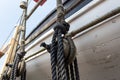 Vintage block and tackle with wrapped ropes against the hull of an old wooden lifeboat, nautical theme