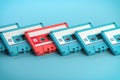 Vintage blue audio cassettes and one unique pink cassete on blue background. Creative retro concept of individuality