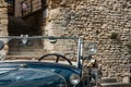 Vintage blue car windscreen and lights in close-up parked in front historic stone building