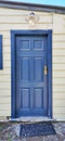 Vintage blue door with light coloured weatherboard wall and street light