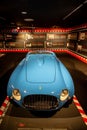 Vintage blue Ferrari sports car displayed inside a museum in Italy.