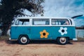 Vintage blue hippie Volkswagen van with flowers at Gola del Ter beach