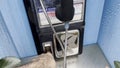 Vintage Blue outdoors public payphone booth finger in coin slot