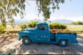 A Vintage Blue Pickup Truck Loaded With Colorful Pumpkins, With Misty Mountains In The Background
