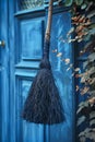 Vintage Blue Witch Broomstick Hanging on Blue Wooden Door with Climbing Plants