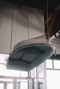 Vintage boat suspended from the ceiling in a rustic interior space with large windows and natural light Royalty Free Stock Photo