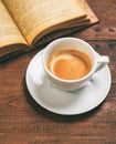 Vintage book and a cup of coffee on wooden background. Break, appointment at a cafe with an espresso and a book Royalty Free Stock Photo