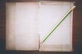 Vintage book and pencil, open on wooden background