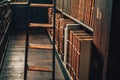 Vintage books in leather covers on bookshelf cabinet with ladder on wooden floor. Royalty Free Stock Photo