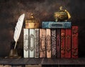 Vintage books on a shelf, ancient caskets, manuscript and antiquarian inkwell with a feather. Royalty Free Stock Photo