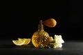 Vintage bottle of perfume, beautiful flower and fruit on black background