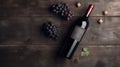 Vintage bottle of red wine with blank matte black label, bunch of grapes on wooden table, concrete wall background. Expensive Royalty Free Stock Photo