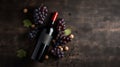 Vintage bottle of red wine with blank matte black label, bunch of grapes on wooden table, concrete wall background. Expensive Royalty Free Stock Photo