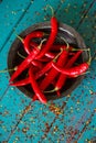 Vintage bowl with chilli pepers over seeds on table Royalty Free Stock Photo