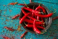 Vintage bowl with red pepers over dried chilli in background Royalty Free Stock Photo