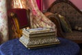 Vintage box. Antique casket on the table against the background of a classic interior consisting of a chair curtains and couch