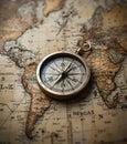 Vintage compass resting on antique world map for exploration and travel concepts Royalty Free Stock Photo