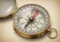 A vintage brass compass with a protective lid partially open. The compass features the cardinal Royalty Free Stock Photo