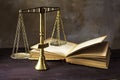 Vintage brass scales of justice and an old book on a brown woode Royalty Free Stock Photo