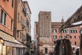 a tall brick tower standing behind some shops on a street