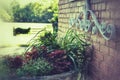 Vintage brick wall with iron ornament and planter with park in background.