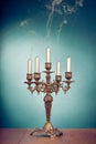 Vintage bronze candlestick with five reek candles in front mint blue background