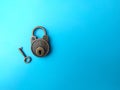 Vintage bronze key and padlock on soft blue paper Royalty Free Stock Photo