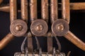 Vintage bronze pipes, valve, key mechanical elements french horn, black background. Good pattern, prompt music instrument. Royalty Free Stock Photo