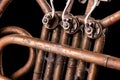Vintage bronze pipes, valve, key mechanical elements french horn, black background. Good pattern, prompt music instrument. Royalty Free Stock Photo