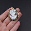 Gold cameo in hand on dark background. Royalty Free Stock Photo
