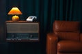 Vintage Brown leather armchair in loft design apartment..Old landline phone, vinil radio recorder and retro yellow lamp