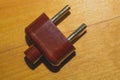 Vintage brown power plug without cord on the wooden background Royalty Free Stock Photo
