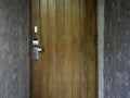 Vintage brown wooden door with modern electronic keycard lock system. Royalty Free Stock Photo