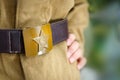 Vintage buckle with the image of a star, hammer and sickle from the Great Patriotic War, worn on a khaki military Royalty Free Stock Photo