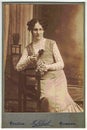 Vintage cabinet card shows woman posing in a photo graphic studio. Photo was taken in Austro-Hungarian Empire or also Austro-
