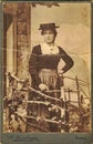 Vintage cabinet card shows woman posing in a photo graphic studio. Photo was taken in Austro-Hungarian Empire or also Austro-