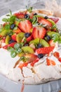 Vintage cake stand with Meringue dessert Pavlova with sugar powder, fresh strawberries, kiwi, blueberries and mint. Homemade Royalty Free Stock Photo