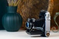 Vintage camera with bellows, accordion on a white table. Royalty Free Stock Photo