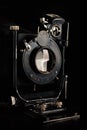 Vintage camera on a black background. Close-up of the lens of an old camera open Royalty Free Stock Photo