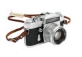 Vintage camera with brown leather strap and lens cap resting on a white background Royalty Free Stock Photo