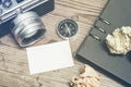 vintage camera, crumple paper,compas and planner book layout on wooden floor.