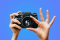 Vintage Camera in female hand. A photo. Photographer. Manual focus. Colored background. Blue