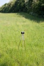 Vintage camera tripod on green meadow Royalty Free Stock Photo