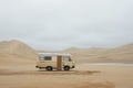 Vintage camper van parked on desert sands Royalty Free Stock Photo