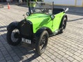 Vintage car: Austin 7 or Baby Austin, light green, convertible, parked, with the top retracted.