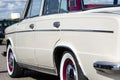 vintage car. beige retro car. on the chrome details a sunny highlight. rear side view. sun against the sky