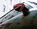 Vintage car detail, concept of British Patriotism shown as flag on mirror, trees in reflection windshield Royalty Free Stock Photo