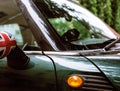 Vintage car detail, concept of British Patriotism shown as flag on mirror, trees in reflection windshield Royalty Free Stock Photo