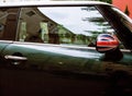 Vintage car detail, concept of British Patriotism shown as flag on mirror, trees in reflection windshield Royalty Free Stock Photo